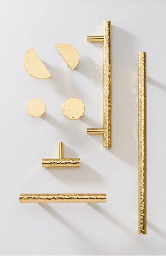 Angle view of STRATFORD hammered brass handle showing hand-forged texture and substantial bar form