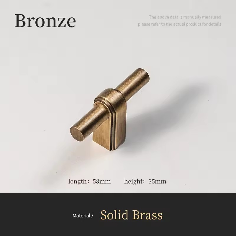 Close-up detail of solid brass T-bar cabinet handle surface texture and warm gold-toned finish