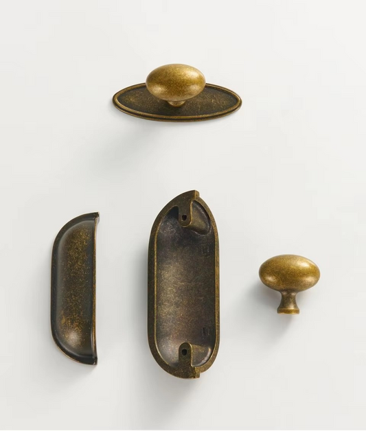 Distressed brass cup handle angled to show the curved bowl depth and hand-finished antique brass surface