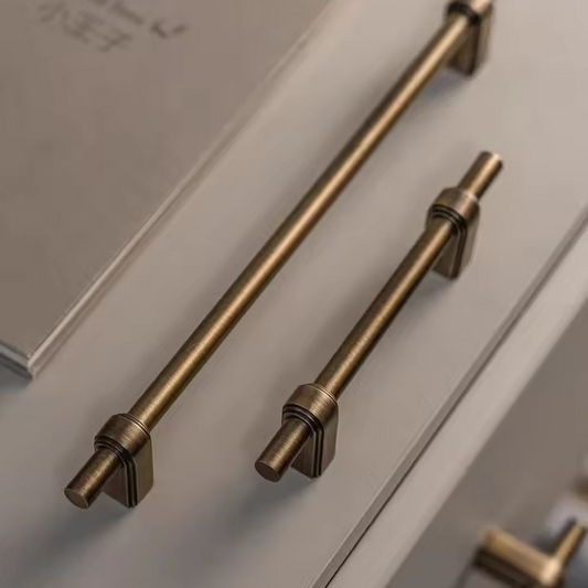 Solid brass cabinet pull handle angled view showing the cylindrical bar and mounting end caps