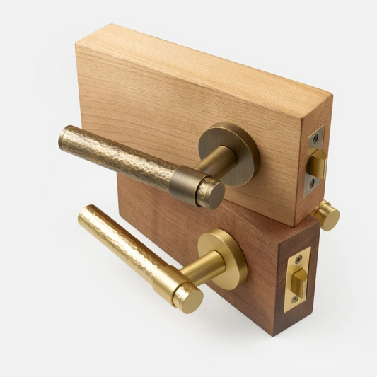 Hammered brass door lever handle close-up showing unique hand-finished texture and weighted feel