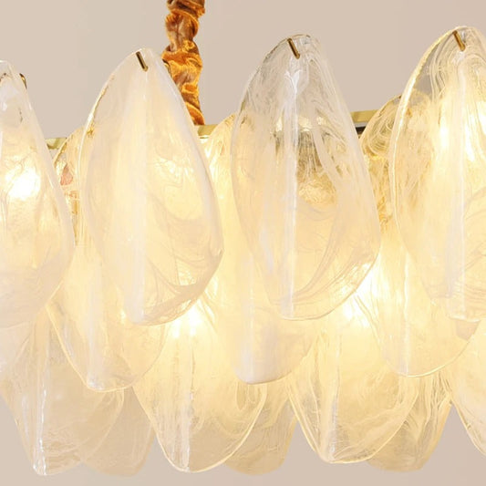 Linear glass chandelier angled view showing the row of glass shades and brass arms