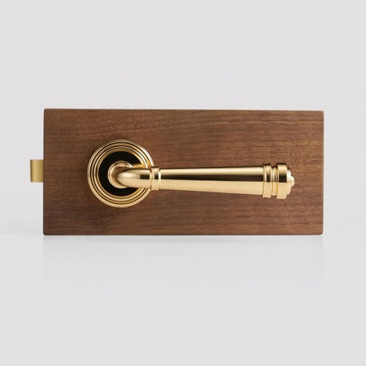 Gold brass door lever handle close-up showing ornate French-Italian silhouette and weighted profile
