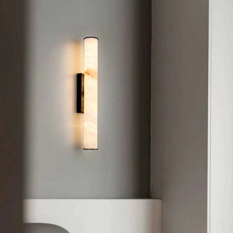 Detail of Lorenzo cylindrical marble wall sconce warm ambient glow and natural stone veining