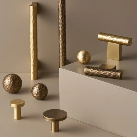 Hammered brass cabinet knob close-up showing bespoke organic texture and weighted construction