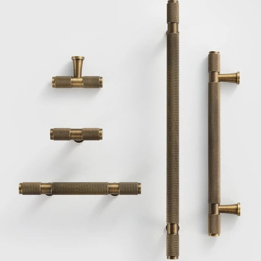 QUILL diamond-knurled pull bar photographed at an angle to highlight the cut-knurl texture and end caps