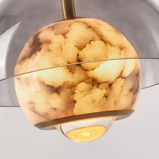 Lucia alabaster pendant light angled view highlighting organic stone texture and brass hardware