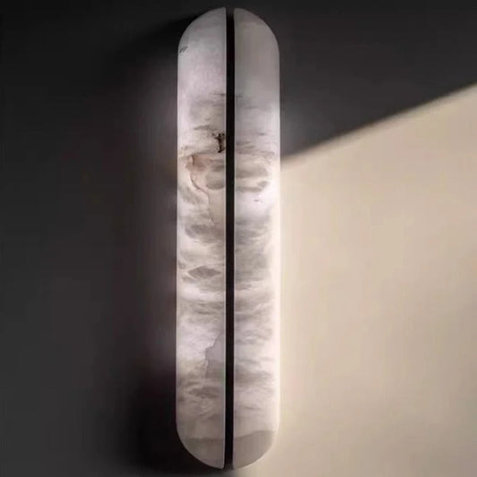 Giulietta marble wall lamp lifestyle shot illuminated on a plastered wall in a luxury bedroom