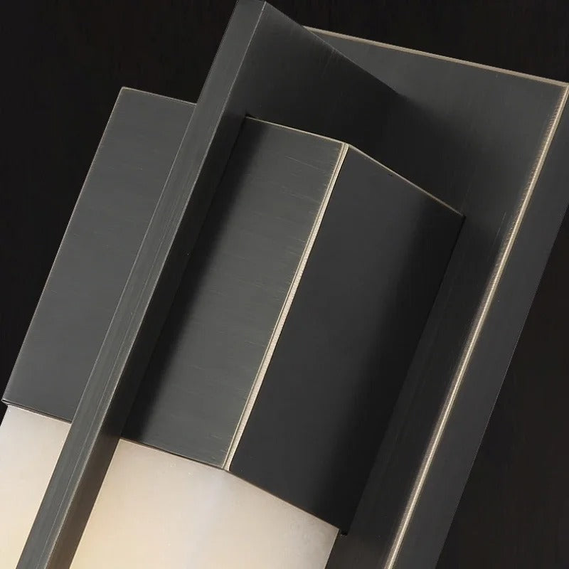 Lifestyle image of VITTORIA copper alabaster double sconce lamp illuminated on a bedroom wall beside a headboard