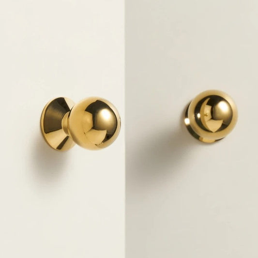 Solid brass cabinet knob angled to show base plate and fixing stud against a neutral background