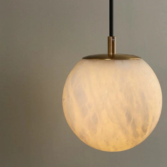 Aurélia wall lamp side-angle view showing brass arm curvature and alabaster globe