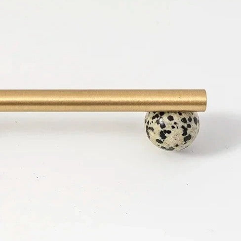 Banti marble brass handle angled view showing stone grain and metal end caps