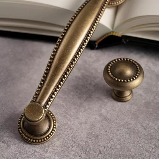 Angled view of LANCASTER antique bronze brass cabinet pull revealing curved bar profile and end details