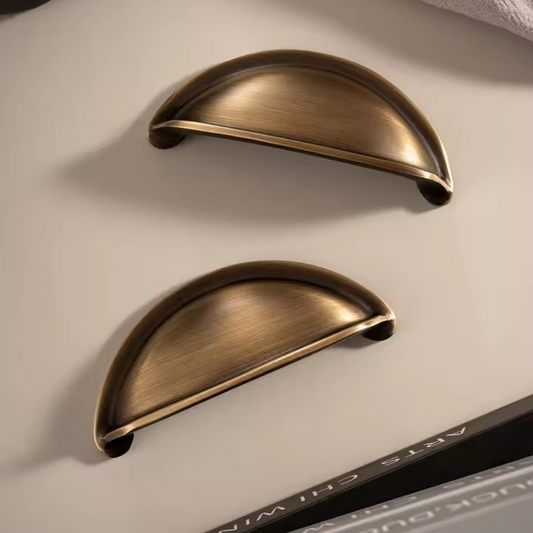 ELLINGTON antique brass cabinet cup pull, hero shot on a white background showing brushed antique brass finish