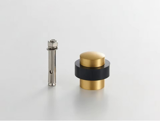 Angle view of plain solid brass doorstop showing smooth barrel profile and sturdy floor-fixing base plate