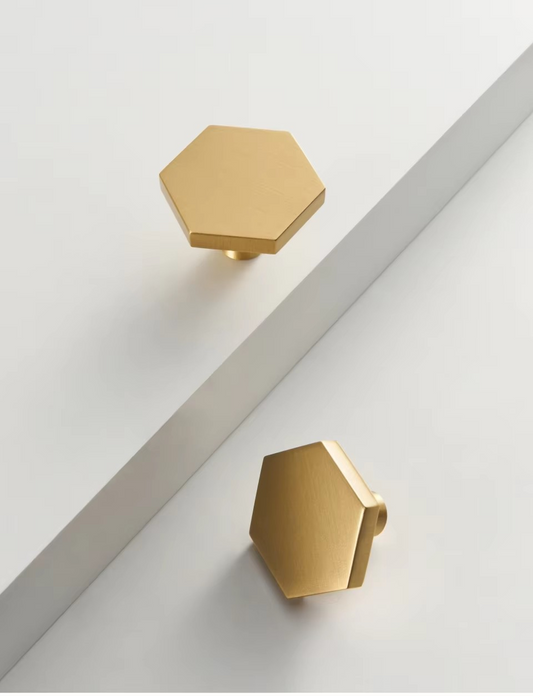 Solid brass hexagonal knob angled view showing bevelled edges and rich burnished gold tone