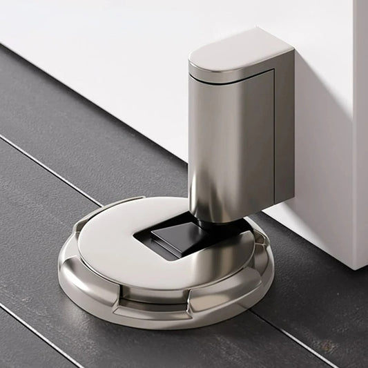 Automatic push-to-lock door stopper in antique brass finish — minimalist round profile