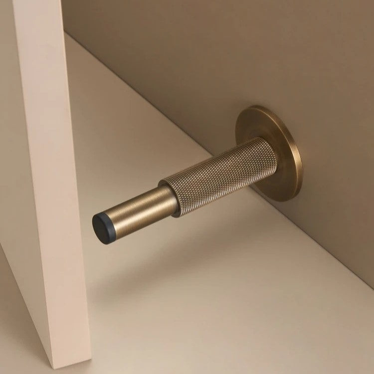 Knurled solid brass door stopper in antique brass — diamond-pattern grip, floor or wall mount