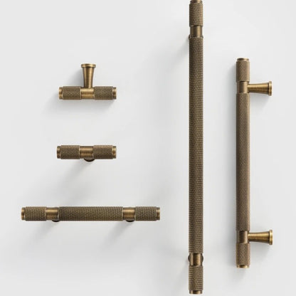 QUILL diamond-knurled pull bar photographed at an angle to highlight the cut-knurl texture and end caps