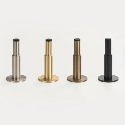 Plain solid brass door stopper styled in modern bathroom with warm antique brass hardware