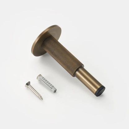 ODETTE knurled solid brass door stopper installed on floor in modern interior