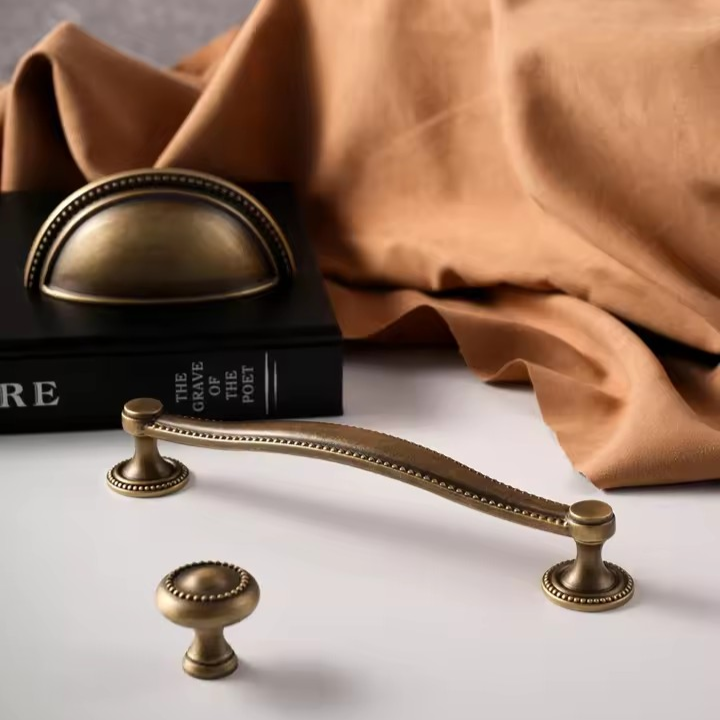 LANCASTER antique bronze solid brass cabinet shell knob hero shot showing shell relief detail on warm brass